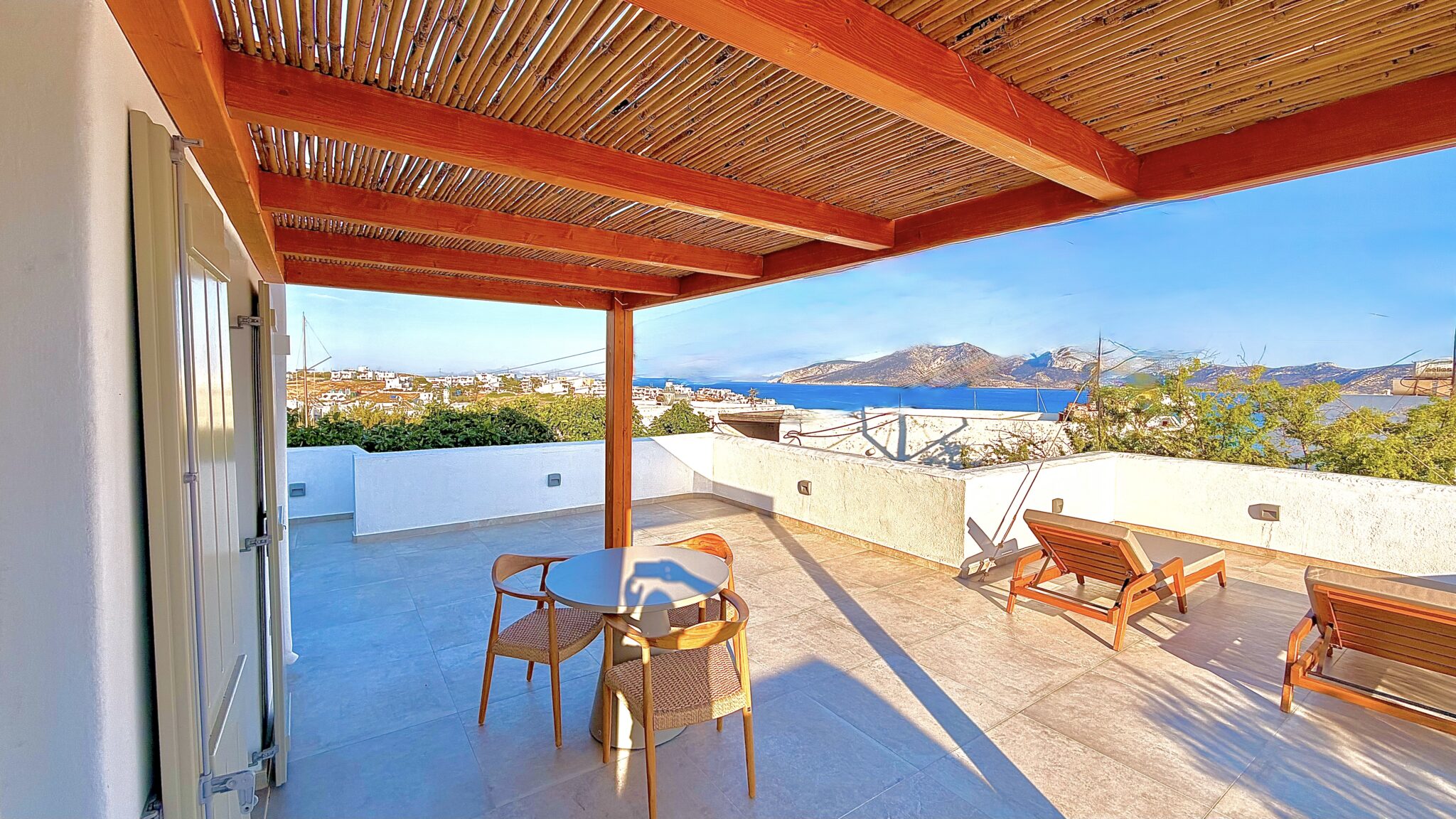 Suite with Jacuzzi – pergola-shaded terrace looking over the rooftops of Chora to the sea