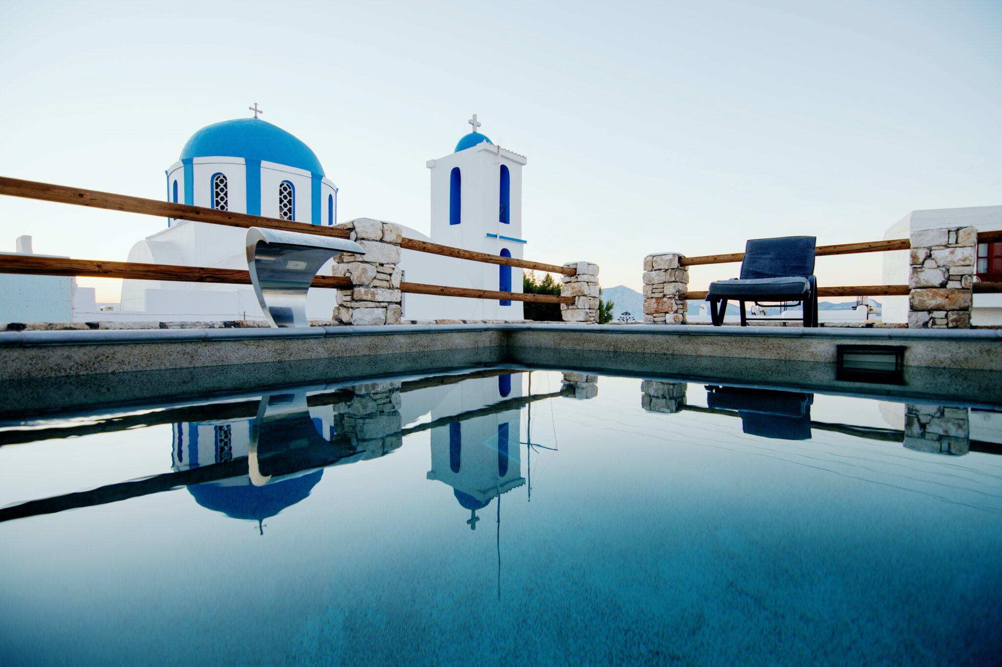 Private pool of the Chora suite with the blue-domed church reflected in the water