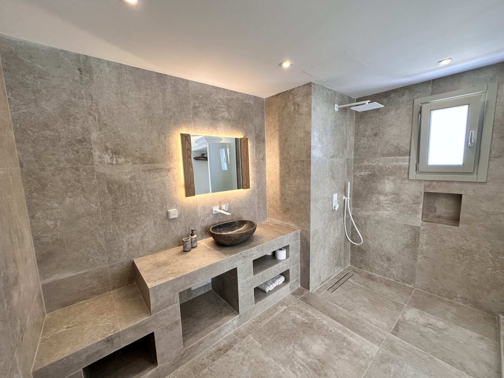 Villa with Semi-private Pool – stone-finish bathroom with basin and backlit mirror