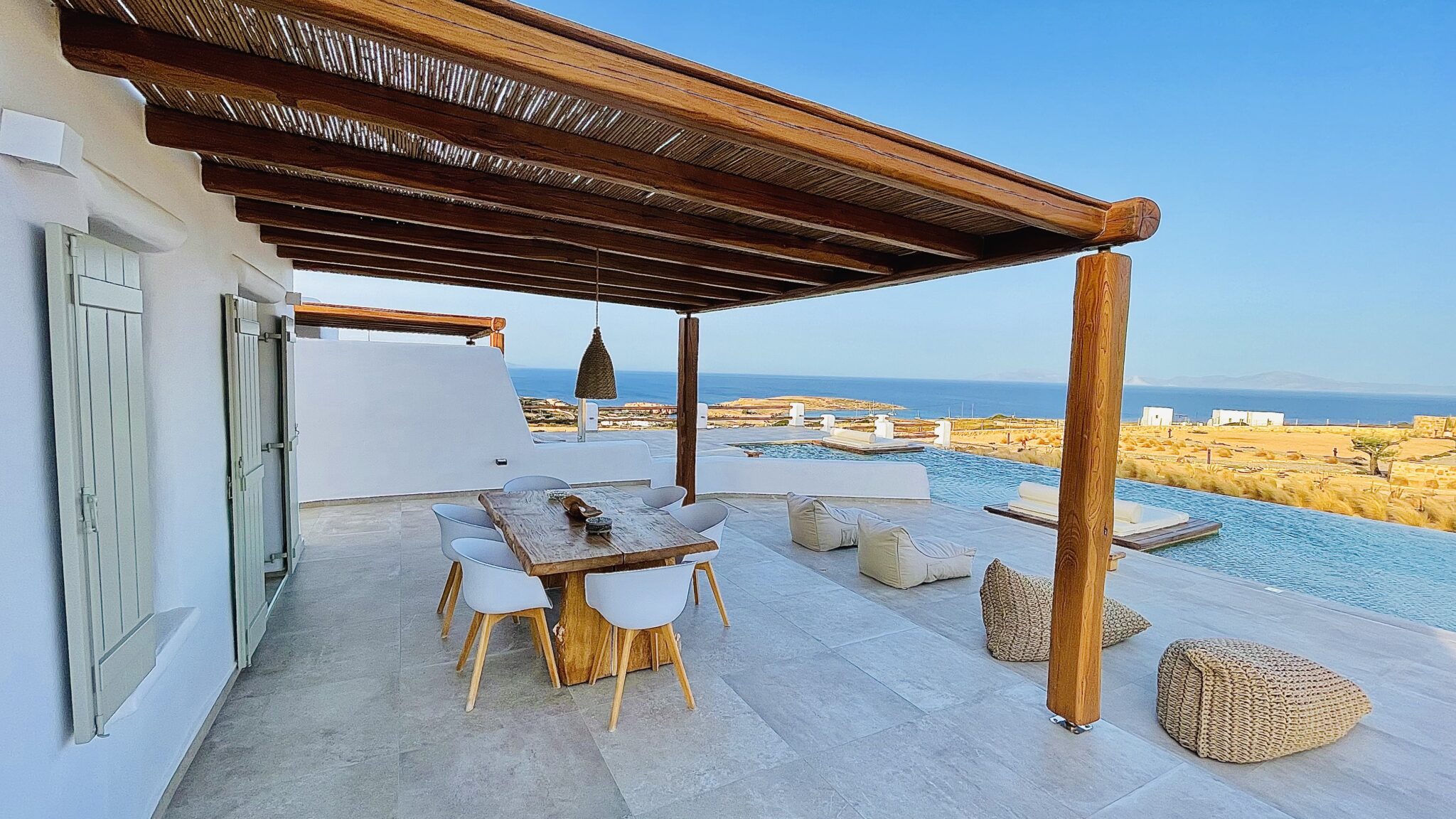 Villa with Semi-private Pool – pergola-shaded terrace with dining table and sea view