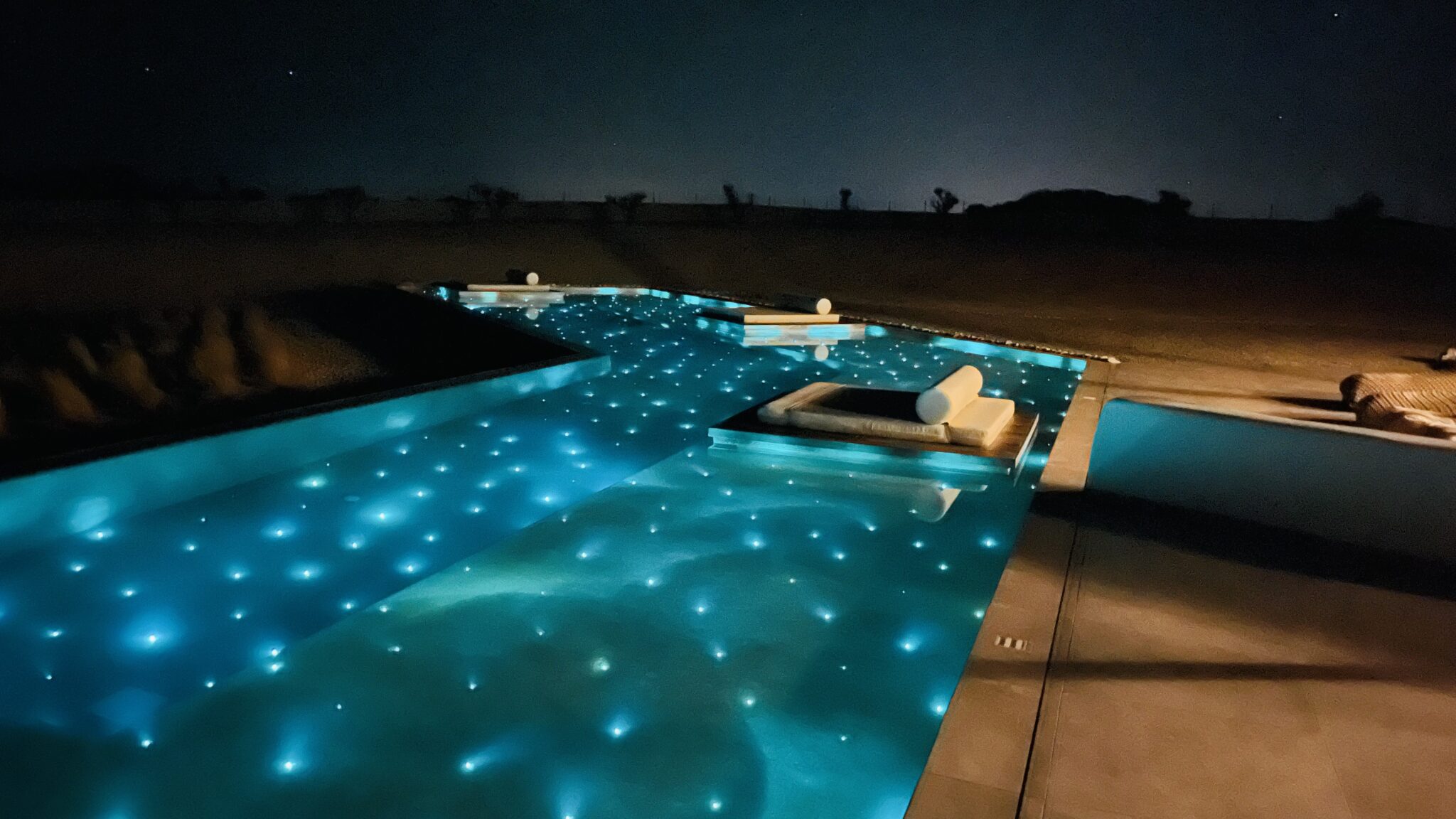 The pool lit under the stars